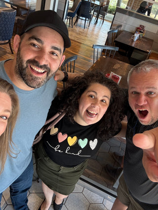 Four people taking a selfie from above in a restaurant setting