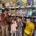 Four children posing in front of a bookshelf filled with various books.