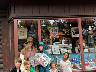 Katie Weaver and her children standing in front of a store named 'MacDonald Book Shop'.